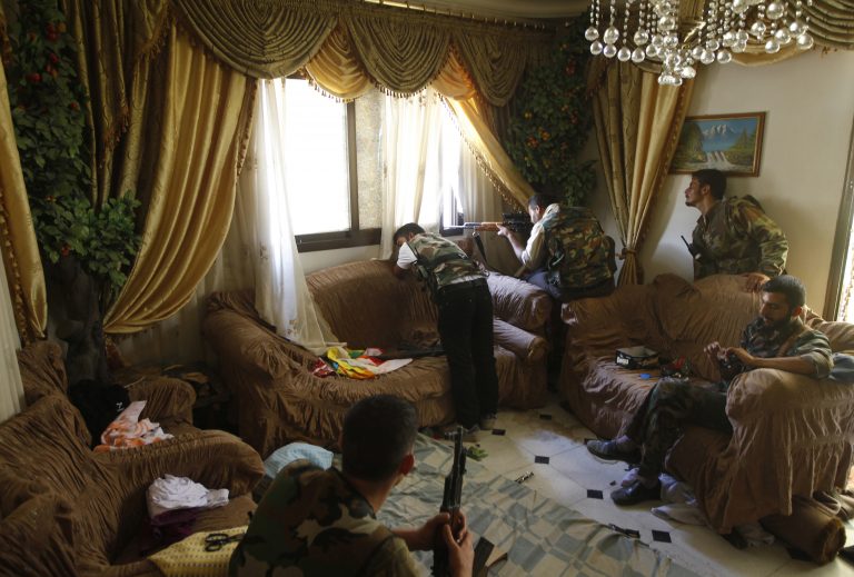 A Free Syrian Army fighter fires his sniper rifle from a house in Aleppo in this August 14, 2012 file photo. Some fighters took position in the living room of a family house. One rebel sits on the chair eating a chocolate bar as the commander looks out the window to scout the area beside a rebel firing from the window. They told me it was a former Syrian army position and they had killed three soldiers in the house - I could see tracks of blood in the corridor -  and taken over their position. There was no one else in the house, except the rebels. REUTERS/Goran Tomasevic/Files (SYRIA - Tags: CIVIL UNREST TPX IMAGES OF THE DAY)

ATTENTION EDITORS - PICTURE 07 16 FOR PACKAGE 'INSIDE SYRIA WITH REBELS' - RTR371GS