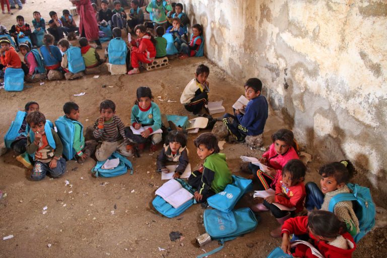 Syrian children sit during class a barn that has been converted into a makeshift school to teach internally displaced children from areas under government control, in a rebel-held area of Daraa, in southern Syria on November 10, 2016. The school has a shortage of seats prompting many children to sit on stones instead.
Rebels hold most of Daraa province, but the regional capital is largely controlled by the government.

 / AFP PHOTO / MOHAMAD ABAZEED