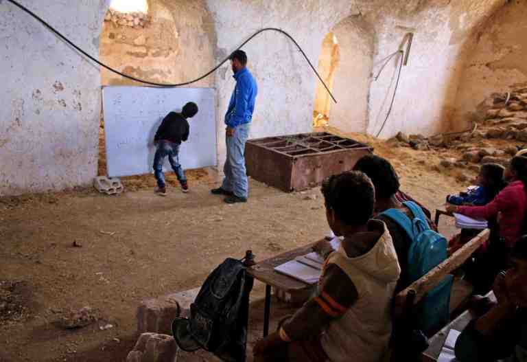 TOPSHOT - A Syrian boy practices basic arithmetic operations with a teacher during class in a barn that has been converted into a makeshift school to teach internally displaced children from areas under government control, in a rebel-held area of Daraa, in southern Syria on November 10, 2016.
Rebels hold most of Daraa province, but the regional capital is largely controlled by the government.

 / AFP PHOTO / MOHAMAD ABAZEEDMOHAMAD ABAZEED/AFP/Getty Images ** OUTS - ELSENT, FPG, CM - OUTS * NM, PH, VA if sourced by CT, LA or MoD **