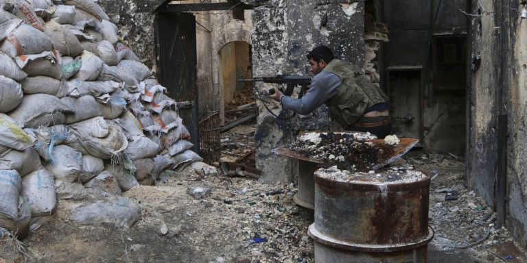 A Free Syrian Army fighter takes a position behind piled sandbags as he aims his weapon near the Justice Palace, which is controlled by forces loyal to Syria's President Bashar al-Assad, in Aleppo March 12, 2014.  REUTERS/Mahmoud Hebbo (SYRIA - Tags: POLITICS CIVIL UNREST CONFLICT) - RTR3GS10