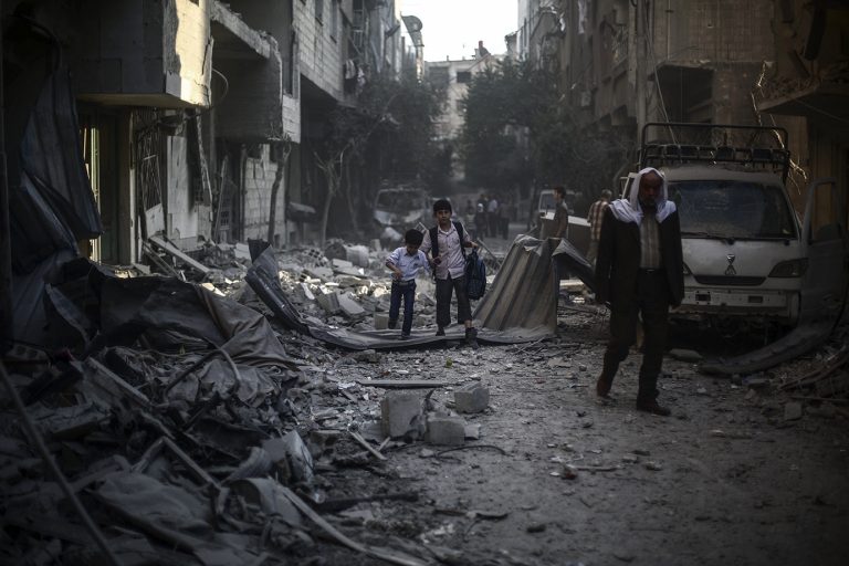 epa04987387 Syrian boys hold hands as they walk amid the rubble of buildings destroyed following an airstrike which according to local reports was conducted by forces loyal to the Syrian Government on the rebel-held area of Douma, outskirts of Damascus, Syria, 21 October 2015. The rebel held territory on the outskirts of Damascus has been one of the most targeted by regime airstrikes, which includes the use of barrel bombs, resulting in the deaths of hundreds of civilians, leaving thousands injured and the town in ruins.  EPA/MOHAMMED BADRA