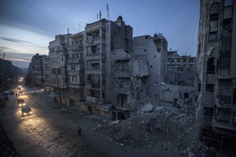 In this Thursday, Nov. 29, 2012 photo, night falls on a Syrian rebel-controlled area as destroyed buildings, including Dar Al-Shifa hospital, are seen on Sa'ar street after airstrikes  targeted the area last week, killing dozens in Aleppo, Syria. (AP Photo/Narciso Contreras)