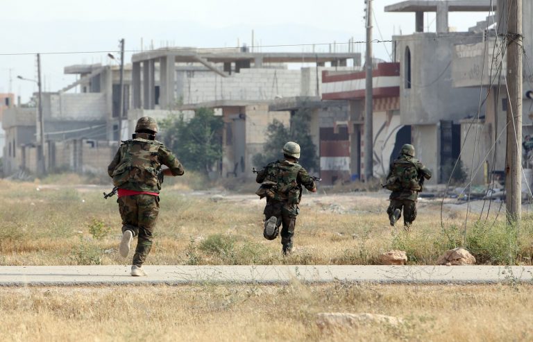 Syrian Army soldiers run during a battle against opposition fighters in the city of Qusayr, in Syria's central Homs province, on May 23, 2013. Syrian government troops launched a week ago an assault on Qusayr and the intervention of hundreds of fighters of Shiite militant group Hezbollah from neighbouring Lebanon has given the regime the upper hand in the battle.   AFP PHOTO/STR == LEBANON OUT==             (Photo credit should read STR/AFP/Getty Images)