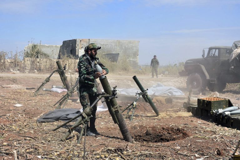 In this photo released by the Syrian official news agency SANA, Syrian army soldiers prepare to launch a mortar towards insurgents in the village of Kfar Nabuda, in the countryside of Hama province on Saturday, May 11, 2019. The Britain-based Syrian Observatory for Human Rights said government forces are now in control of nine villages forming an L shape at the far southern corner of the rebel stronghold. The villages include the strategic village of Kfar Nabuda and the elevated Qalaat Madiq, giving the government troops an advantage over the insurgents. (SANA via AP)