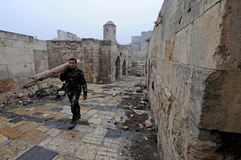 A member of forces loyal to Syria's President Bashar al-Assad carries a tree branch as he walks inside Aleppo's historic citadel, during a media tour, Syria December 13, 2016. REUTERS/Omar Sanadiki