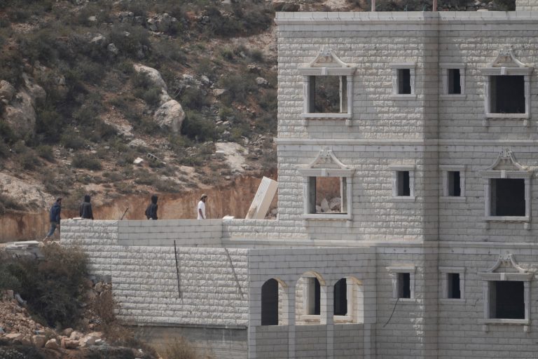 Israeli settlers enter Palestinian properties in the occupied West Bank village of Qusra, Saturday, Aug. 29, 2026. (AP Photo/Majdi Mohammed)