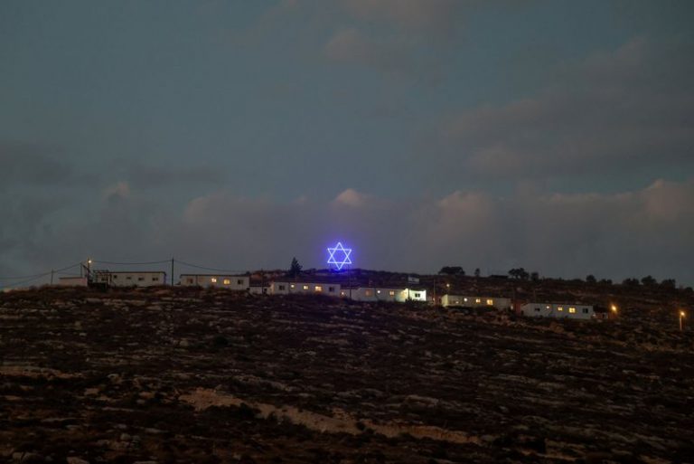 An illuminated Star of David above an Israeli settlers outpost near Ramallah, in the Israeli-occupied West Bank, August 14, 2026. REUTERS/Ammar Awad